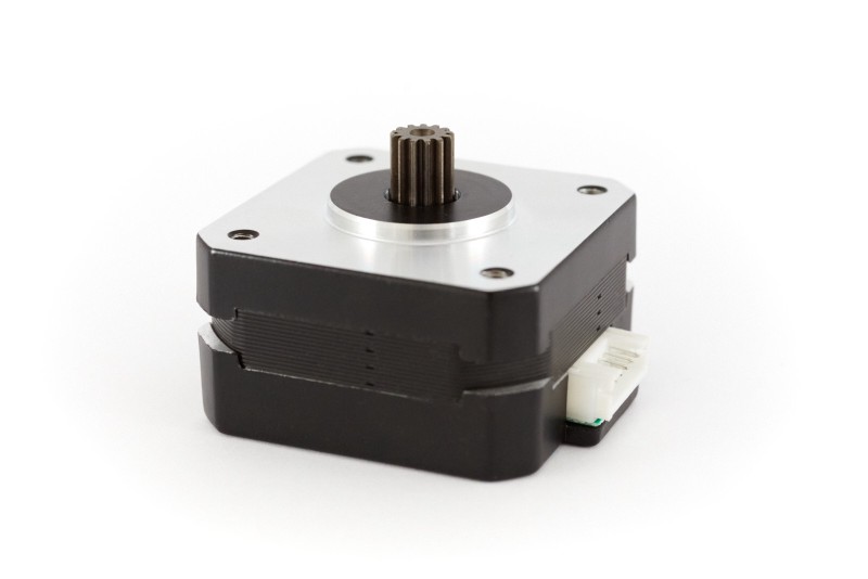 View of a Nema 17 pancake motor laying on its back. The motor gear is coated and has a hole in the middle to reduce the weight