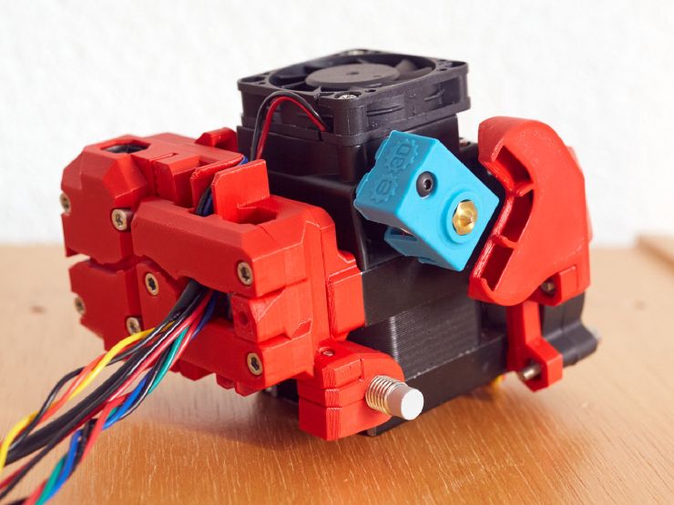 Underneath view of the BearMera with red PETG parts. We can see the nozzle fan duct outlet, the tip of the SuperPinda and the carriage we cables going out