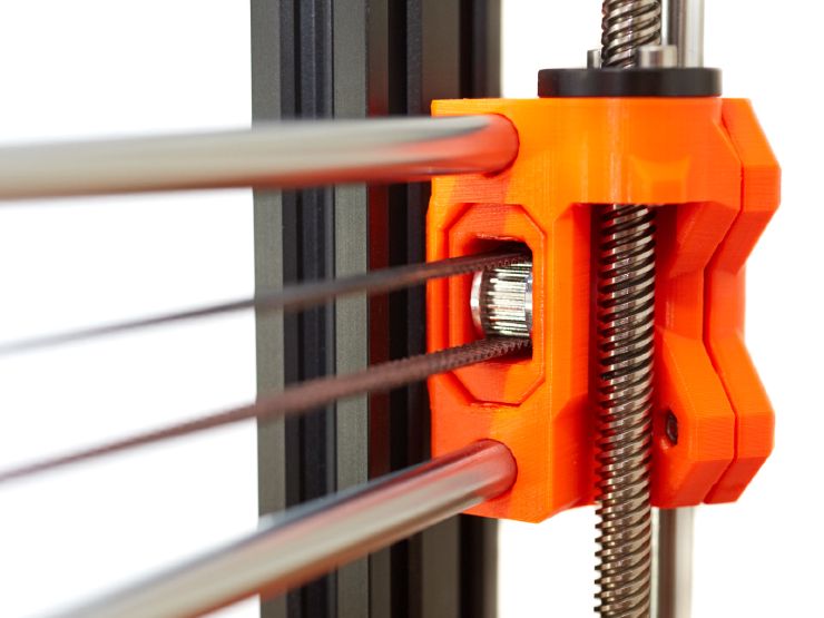 A close view of the belt tensioner of the X axis with parts printed in orange PETG