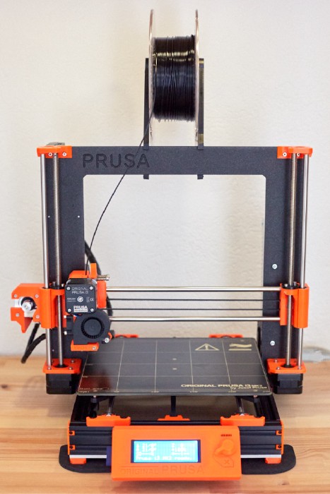 Photo of the MK2S fully assembled with the Bear Frame 1.0 in black and the printed part in orange